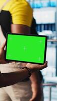 Vertical Smart factory technician manages robotic arms using mockup notebook, close up. Engineer in industry 4.0 industrial plant controls automated machinery using green screen laptop, camera A video