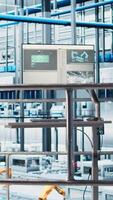 Vertical Monitor displaying industrial automation software overlooking industry 4.0 smart factory with robotic arms, modular production units, connected machines and control systems video