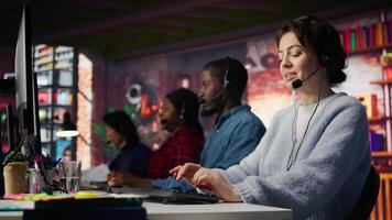 Customer support employees listening to clients issues. Teamworking call center agents in front of PC in office using headset mic to provide helpful solutions, solving customers concerns, camera B video
