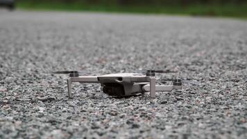 A drone placed on the road and ready to take off. The quadcopter takes off. video