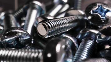 Chrome bolts close up. A bunch of bolts are scattered on the table. video