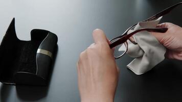Close-up of a person cleaning eyeglasses with a cloth, emphasizing the importance of lens care and maintaining clear vision. video