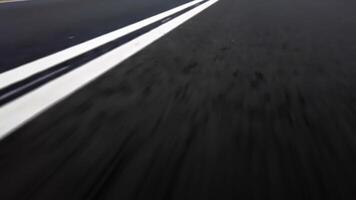 Low-angle, close-up view of white road markings on a freshly paved asphalt highway, emphasizing speed, travel, and road infrastructure. video