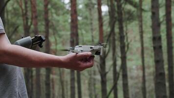 The pilot with the remote control in his hands launches the drone. The drone takes off from the operator's hand. video