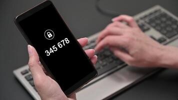 A woman's hand enters a one-time password for the verification process. Two factor authorization video