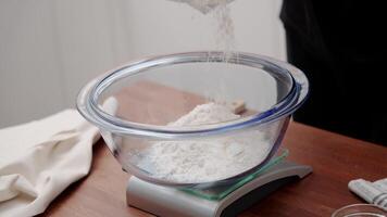 The cook measures flour for baking bread. the cook kneads the dough according to the recipe. video