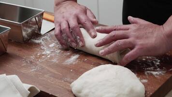 The cook hands form the dough and place it in the pan. the cook kneads the dough. video