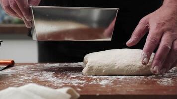 Close-up of hands shaping the dough and placing it into the pan. the cook kneads the dough. video