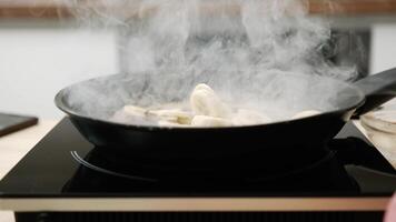 Add raw chopped bananas to the pans. Raw sliced bananas boiled in oil. Caramelization of bananas in the kitchen. video