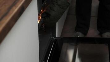 Close-up of a chef's hands taking baked bread out of the oven. the cook bakes bread. video