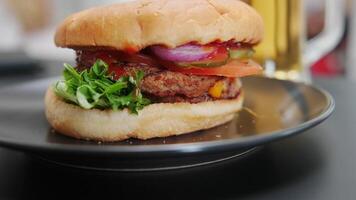 Fresh tasty burger on the table. classic beef burger with cheese, tomatoes, onions and bacon, accompanied by sauce. video