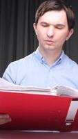 vertical Office worker reading documents in a red folder at night video