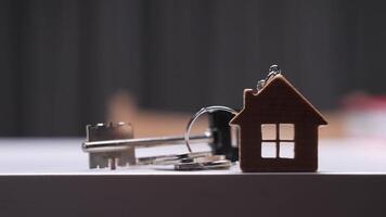 House shaped keychain and keys resting on table symbolizing new home purchase video