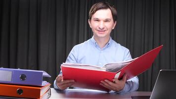 Accountant smiling and reviewing documents in a folder at night video