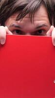 vertical Office worker hiding behind red folder on abstract background video