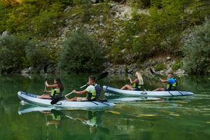 A group of friends enjoying having fun and kayaking while exploring the calm river, surrounding forest and large natural river canyons photo