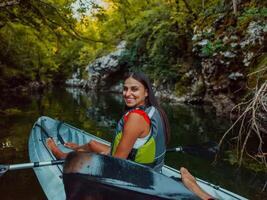 A smiling woman enjoying a relaxing kayak ride with a friend while exploring river canyons photo