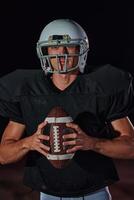 American Football Field. Lonely Athlete Warrior Standing on a Field Holds his Helmet and Ready to Play. Player Preparing to Run, Attack and Score Touchdown. photo