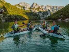 A group of friends enjoying having fun and kayaking while exploring the calm river, surrounding forest and large natural river canyons photo