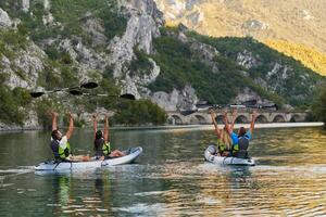 A group of friends enjoying having fun and kayaking while exploring the calm river, surrounding forest and large natural river canyons photo