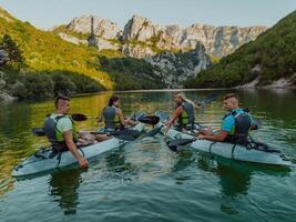A group of friends enjoying having fun and kayaking while exploring the calm river, surrounding forest and large natural river canyons photo
