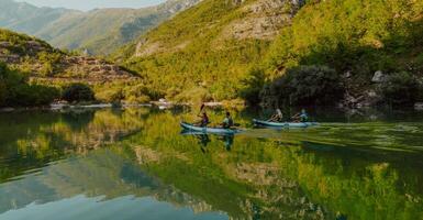 A group of friends enjoying having fun and kayaking while exploring the calm river, surrounding forest and large natural river canyons photo