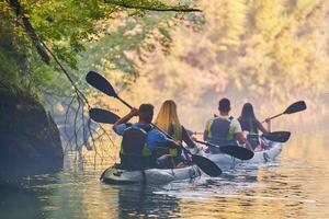 A group of friends enjoying having fun and kayaking while exploring the calm river, surrounding forest and large natural river canyons photo