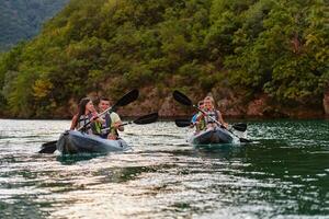 A group of friends enjoying having fun and kayaking while exploring the calm river, surrounding forest and large natural river canyons photo