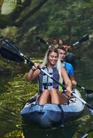 A group of friends enjoying having fun and kayaking while exploring the calm river, surrounding forest and large natural river canyons photo