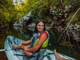 A smiling woman enjoying a relaxing kayak ride with a friend while exploring river canyons photo