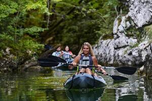 A group of friends enjoying having fun and kayaking while exploring the calm river, surrounding forest and large natural river canyons photo