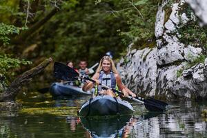 A group of friends enjoying having fun and kayaking while exploring the calm river, surrounding forest and large natural river canyons photo