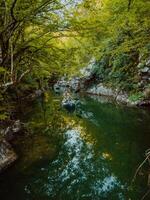 A group of friends enjoying having fun and kayaking while exploring the calm river, surrounding forest and large natural river canyons photo