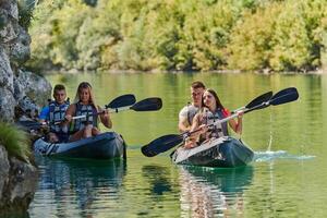 A group of friends enjoying having fun and kayaking while exploring the calm river, surrounding forest and large natural river canyons photo