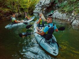 A group of friends enjoying having fun and kayaking while exploring the calm river, surrounding forest and large natural river canyons photo