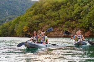 A group of friends enjoying having fun and kayaking while exploring the calm river, surrounding forest and large natural river canyons photo