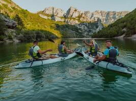 A group of friends enjoying having fun and kayaking while exploring the calm river, surrounding forest and large natural river canyons photo