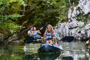 A group of friends enjoying having fun and kayaking while exploring the calm river, surrounding forest and large natural river canyons photo