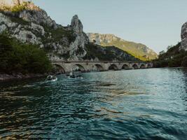 A group of friends enjoying having fun and kayaking while exploring the calm river, surrounding forest and large natural river canyons photo