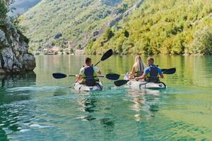 A group of friends enjoying having fun and kayaking while exploring the calm river, surrounding forest and large natural river canyons photo