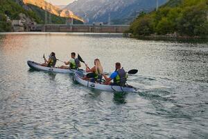 A group of friends enjoying having fun and kayaking while exploring the calm river, surrounding forest and large natural river canyons photo