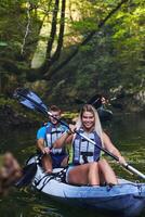 A group of friends enjoying having fun and kayaking while exploring the calm river, surrounding forest and large natural river canyons photo
