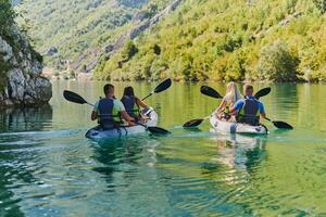 A group of friends enjoying having fun and kayaking while exploring the calm river, surrounding forest and large natural river canyons photo