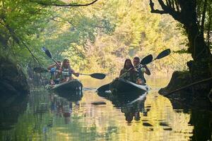 A group of friends enjoying having fun and kayaking while exploring the calm river, surrounding forest and large natural river canyons photo