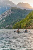 A group of friends enjoying having fun and kayaking while exploring the calm river, surrounding forest and large natural river canyons photo