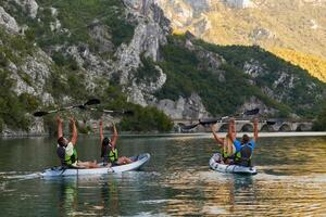 A group of friends enjoying having fun and kayaking while exploring the calm river, surrounding forest and large natural river canyons photo