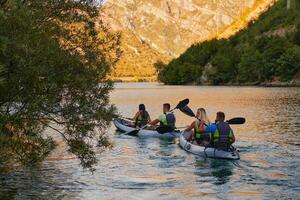 A group of friends enjoying having fun and kayaking while exploring the calm river, surrounding forest and large natural river canyons photo