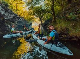 A group of friends enjoying having fun and kayaking while exploring the calm river, surrounding forest and large natural river canyons photo
