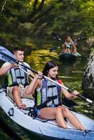 A group of friends enjoying having fun and kayaking while exploring the calm river, surrounding forest and large natural river canyons photo