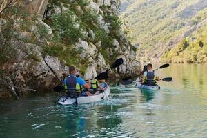 A group of friends enjoying having fun and kayaking while exploring the calm river, surrounding forest and large natural river canyons photo